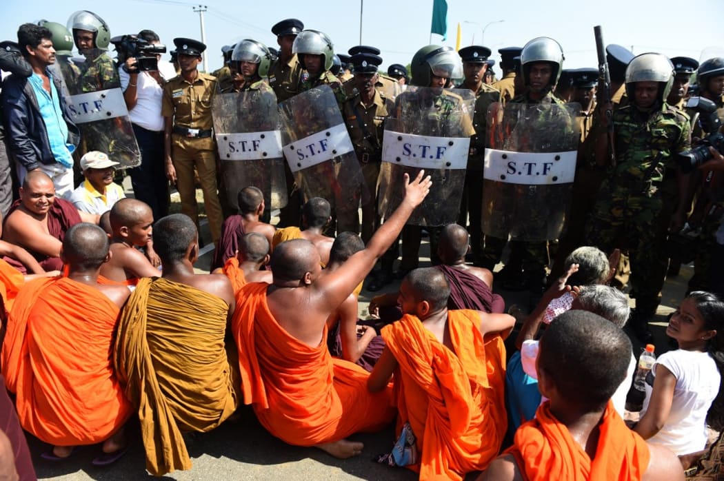 Sri Lankan security personnel and Buddhist monks clash during a protest in the southern port city of Hambantota on January 7, 2017.