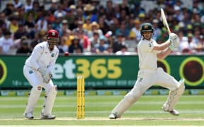 Australian batsman Adam Voges (R) cuts a ball away as West Indies wicketkeeper Denesh Ramdin (L) looks on on the second day of the second cricket Test in Melbourne on December 27, 2015.