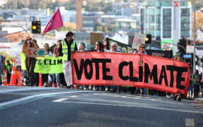 Climate advocates take part on a march in Auckland on 26 May, 2023, demanding New Zealand reduces its emissions, transition to regenerative agriculture, lower the voting age to 16 and respond to the climate crisis with tangata whenua at the center of decision making.