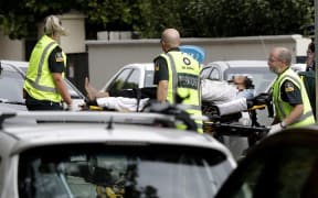 Ambulance staff take a man from outside a mosque in central Christchurch, New Zealand, Friday, March 15, 2019. A witness says many people have been killed in a mass shooting at a mosque in the New Zealand city of Christchurch.(AP Photo/Mark Baker)