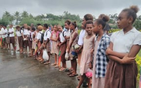 Children are lining the route from the Vanuatu parliament to the airport as the funeral procession takes the President Baldwin Lonsdale back to his home.