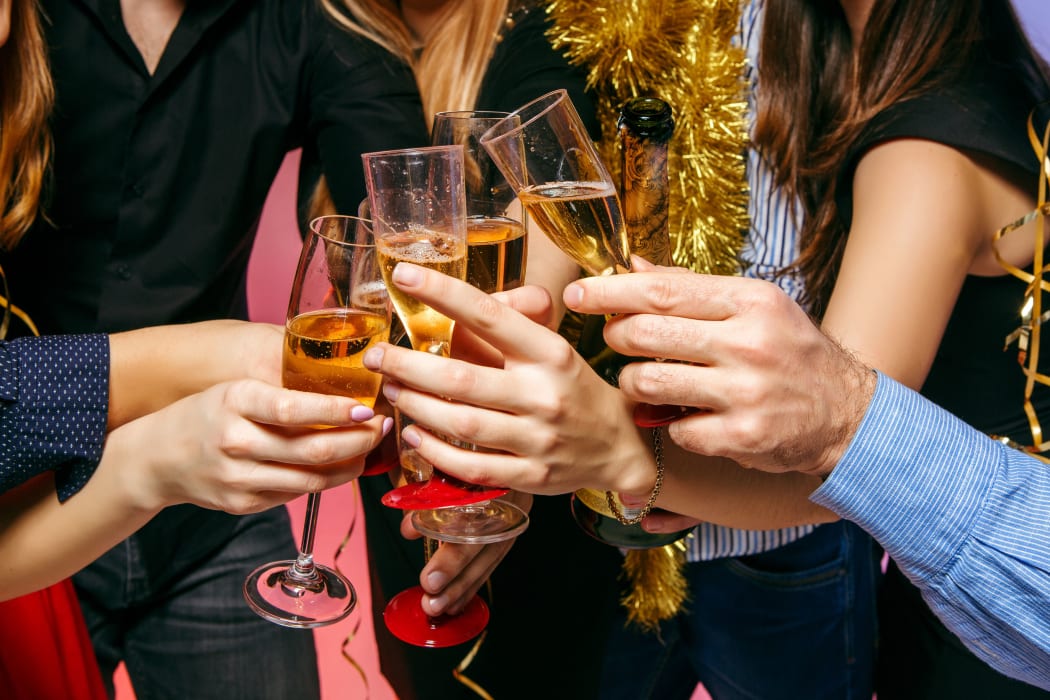 Many young women and men drinking at christmas party on white studio background