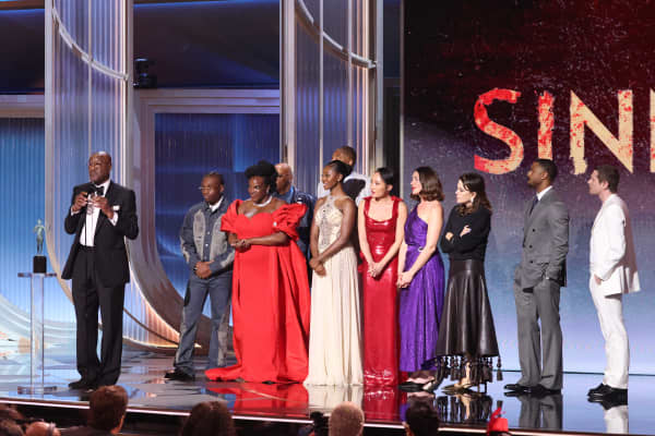 British-US actor Delroy Lindo (L) speaks as the cast of "Sinners" including actors Michael B. Jordan, Hailee Steinfeld, Wunmi Mosaku, Miles Caton, Li Jun Li, Jayme Lawson and Peter Dreimanis accept the award for Outstanding Performance by a Cast in a Motion Picture for Sinners.