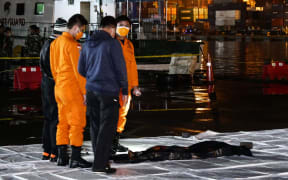 Officers from Sriwijaya Air and The National Search and Rescue Agency of Indonesia ) check a fragment of Indonesian Sriwijaya Air Flight 182 Boeing 737 crashed into the Java Sea on Saturday (9/1) at a Port in Jakarta, Indonesia on January 10, 2021.