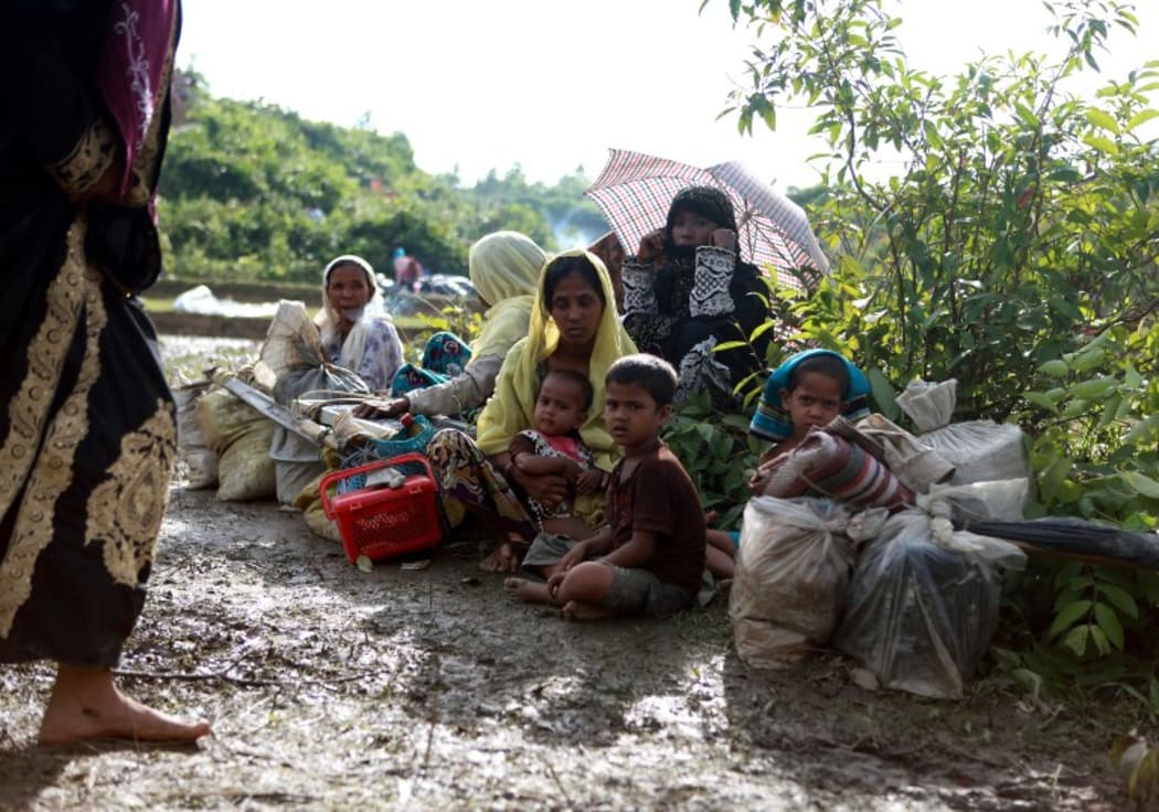 A Rohingya family sit beside a road in Nykkhongchhari, Bangladesh after fleeing violence in Myanmar.