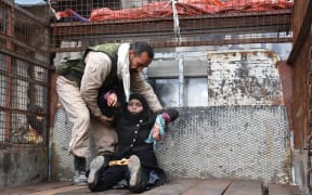 A wounded Syrian woman is helped onto the back of a truck as she flees during the ongoing government forces military operation in Aleppo on 14 December, 2016.