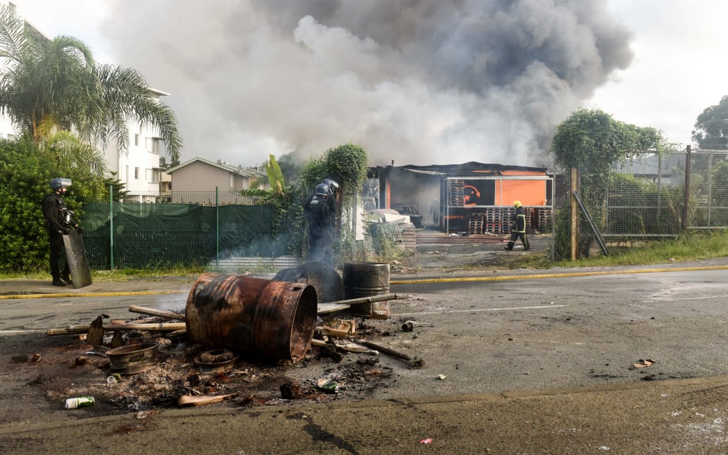 A temporary burning roadblock set up by demonstrators is seen in Noumea on May 14, 2024, amid protests linked to a debate on a constitutional bill aimed at enlarging the electorate for upcoming elections of the overseas French territory of New Caledonia. After scenes of violence of "great intensity" including burned vehicles, looted stores and clashes between demonstrators and the police, a curfew was decreed in Noumea, 17,000 kilometers from Paris, as the independentists of the overseas French territory of New Caledonia oppose a constitutional revision they fear will "further minimize the indigenous Kanak people". (Photo by Mathurin DEREL / AFP)