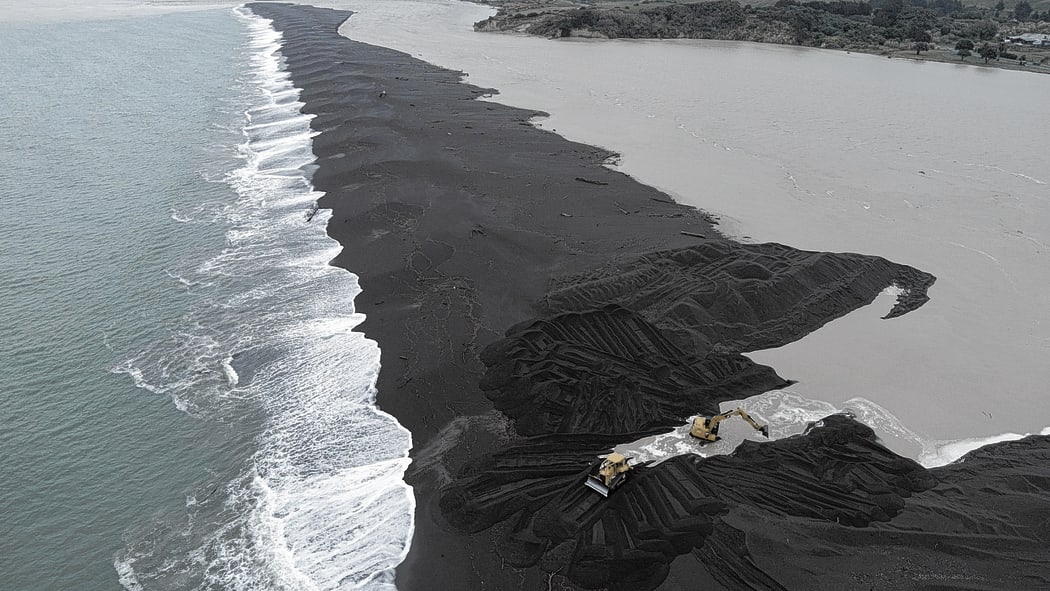 Hamish Pryde and a worker from Pryde Contracting busy opening up the Wairoa River mouth last month in an effort to avert a flooding disaster for the township and low-lying areas.