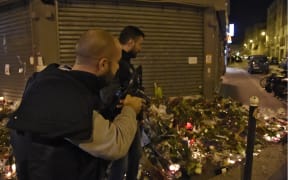 Policemen advance in combat position near "Le petit Cambodge" restaurant one of the site of the attacks in Paris after a crowd movement led to a panic on November 15, 2015.