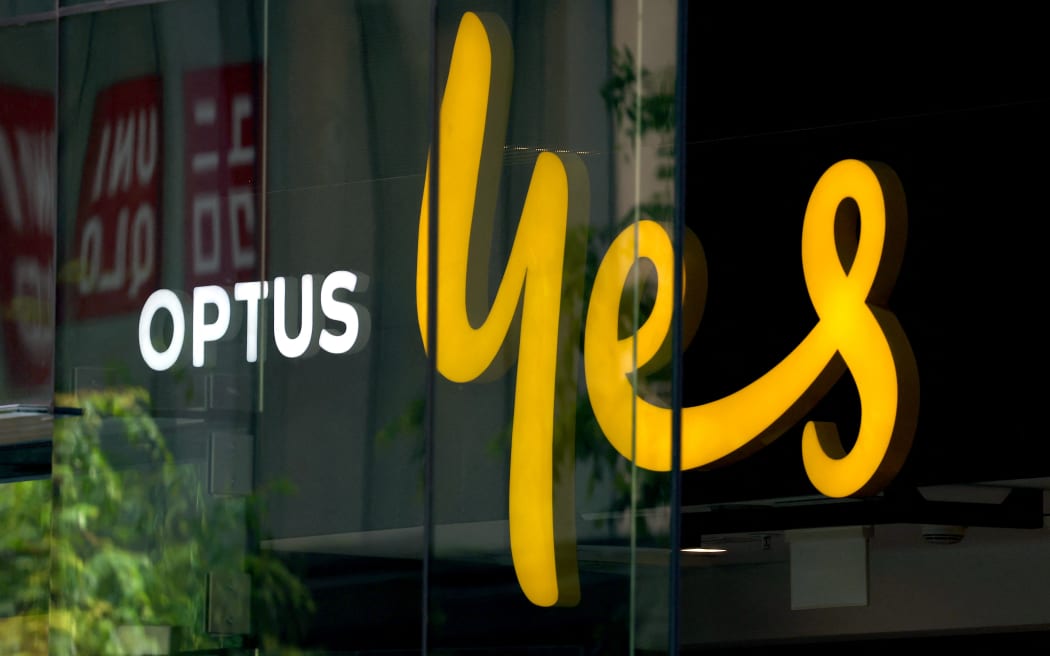 An illuminated sign is displayed in the window of an outlet for the Australian communications company Optus in Sydney on November 9, 2023. Australia's government on November 9 launched an investigation into a nationwide communications outage that crippled phone lines and severed internet access for 10 million customers countrywide. (Photo by DAVID GRAY / AFP)