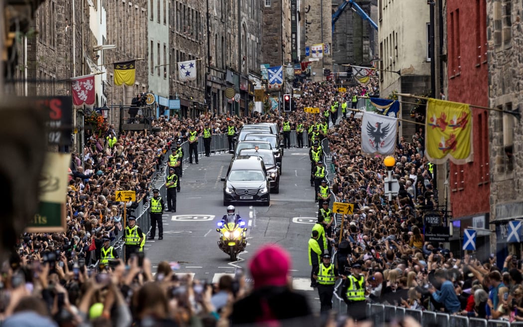 Members of the public gather along the Royal Mile to watch the hearse carrying the coffin of Queen Elizabeth II, as it is driven through Edinburgh towards the Palace of Holyroodhouse, on September 11, 2022.
