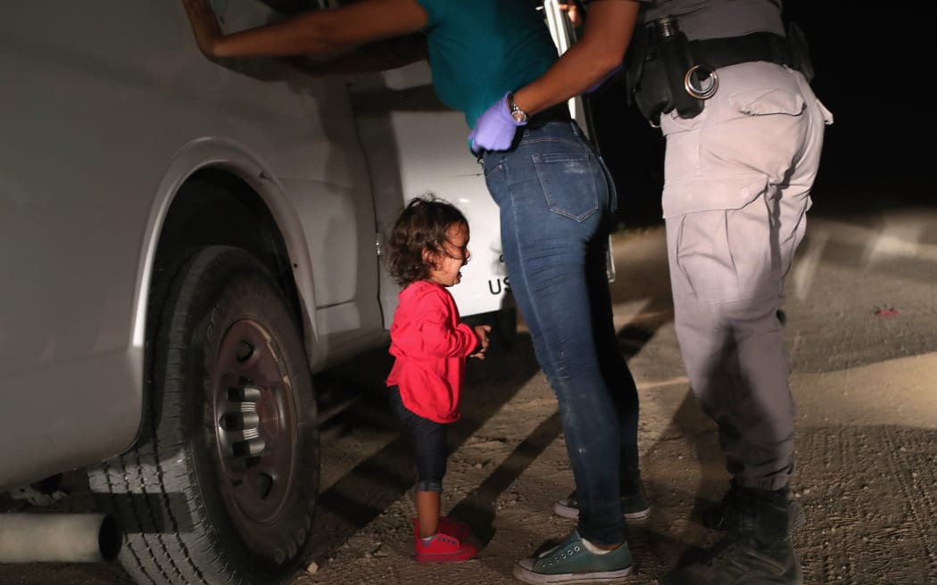 A two-year-old Honduran asylum seeker cries as her mother is searched and detained near the U.S.-Mexico border on June 12, 2018 in McAllen, Texas.