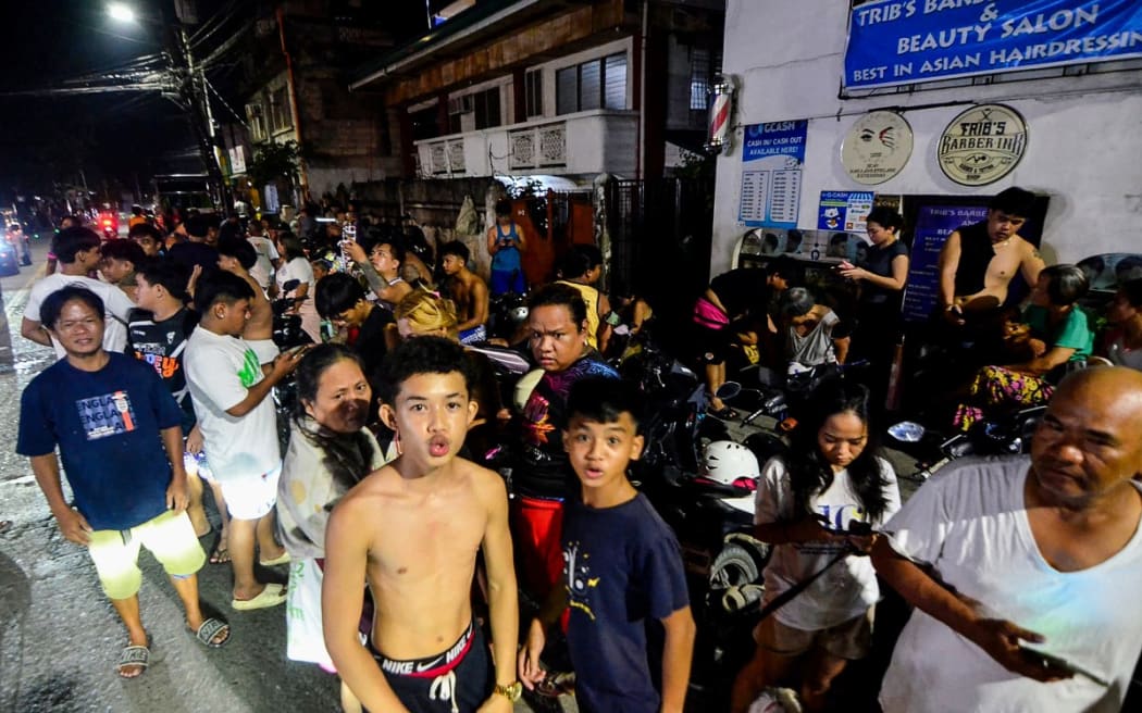 Residents gather on a street outside their homes after earthquake tremors at Mandaue in Cebu, central Philippines on September 30, 2025. A 6.9-magnitude quake struck off the coast of central Philippines on September 30 evening, the US Geological Survey said, with no immediate reports of casualties or damage.