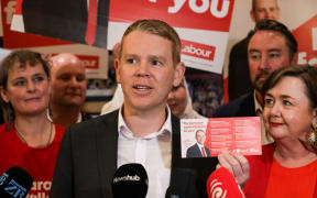 Labour leader Chris Hipkins holding the party's pledge card for the 2023 election.