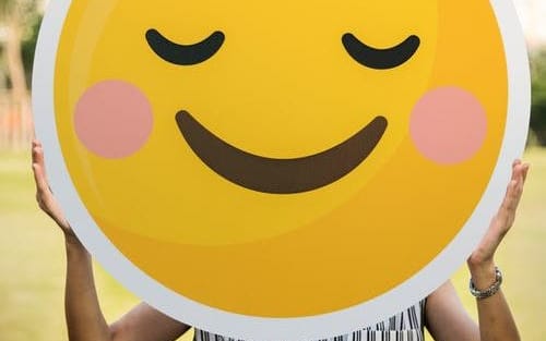 woman holding smiley face