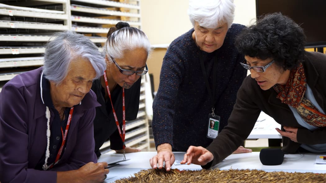 L – R, Matekino Lawless, Awhina Tamarapa, Dr Maureen Lander and Rangi Te Kanawa examining a cloak.