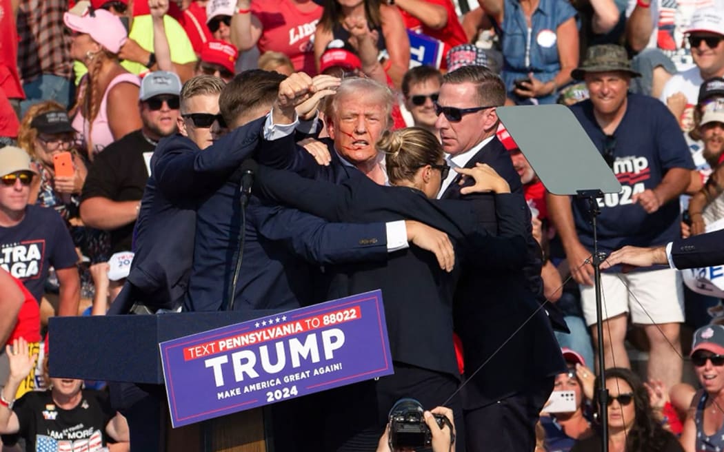 Republican candidate Donald Trump is seen with what appears to be blood on his face surrounded by secret service agents as he is taken off the stage at a campaign event at Butler Farm Show Inc. in Butler, Pennsylvania, July 13, 2024. Republican candidate Donald Trump was evacuated from the stage at today's rally after what sounded like shots rang out at the event in Pennsylvania, according to AFP.
The former US president was seen with blood on his right ear as he was surrounded by security agents, who hustled him off the stage as he pumped his first to the crowd.
Trump was bundled into an SUV and driven away. (Photo by Rebecca DROKE / AFP)