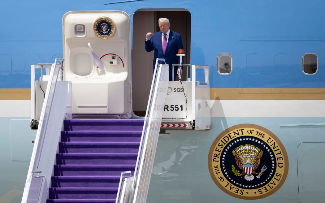 US President Donald Trump gestures as he exits his plane upon arriving at the airport in Riyadh on May 13, 2025. (Photo by Brendan Smialowski / AFP)