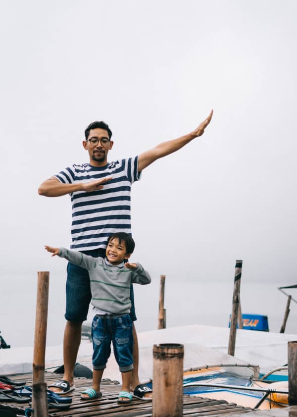 father and son play on a dock