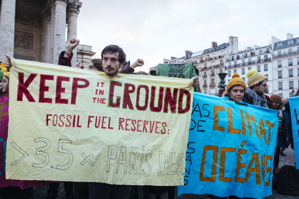 Campaigners urge companies at the  Paris summit to phase out fossil fuels.