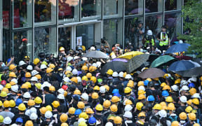 Protesters and journalists gather outside the government headquarters.