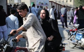 A woman arrives on a motorbike to search for a relative at a hospital in Kabul on September 30, 2022 after a blast in a learning centre in the Dasht-e-Barchi area of Afghanistan's capital. - A suicide bombing at a learning centre in the Afghan capital Kabul killed at least 19 people on September 30 morning, police spokesman Khalid Zadran said.