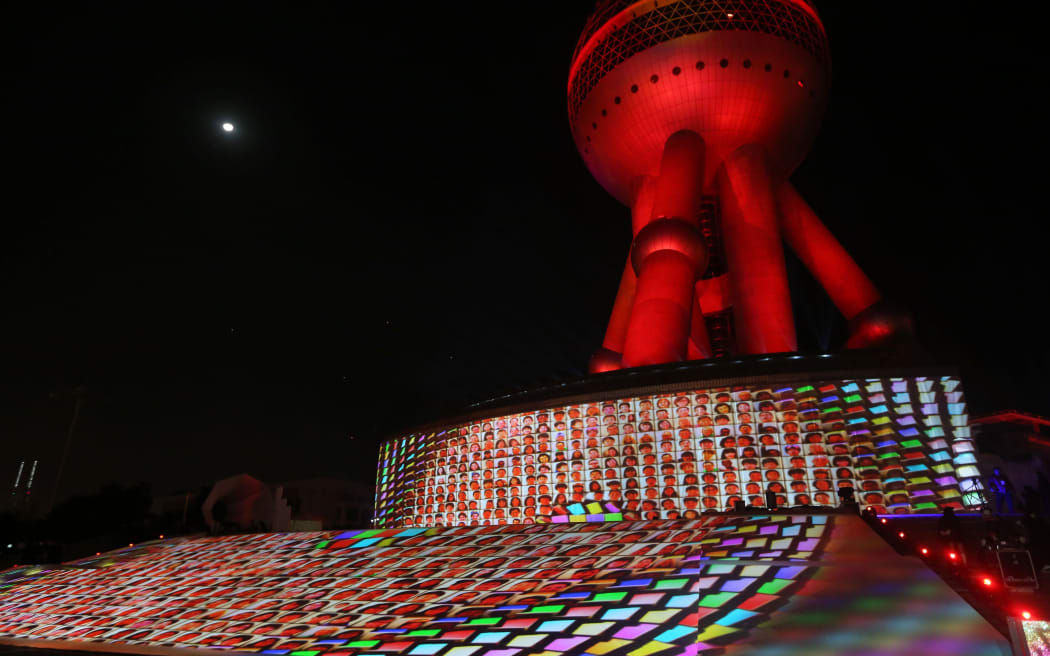 An illuminated portrait photo display is held during a light show in Shanghai.