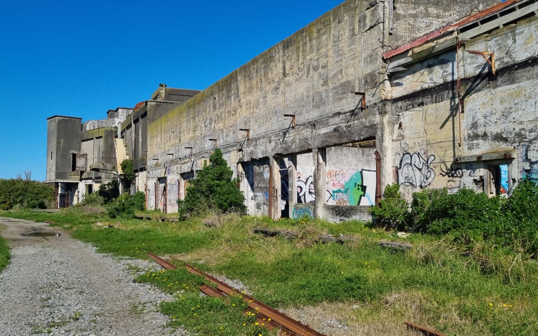 A derelict coolstores building on the banks of the Pātea River in Taranaki.