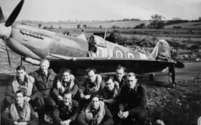 A group of No 485 Squadron pilots in front of one of their aircraft at RAF Station Selsey, at the dawn of D Day.