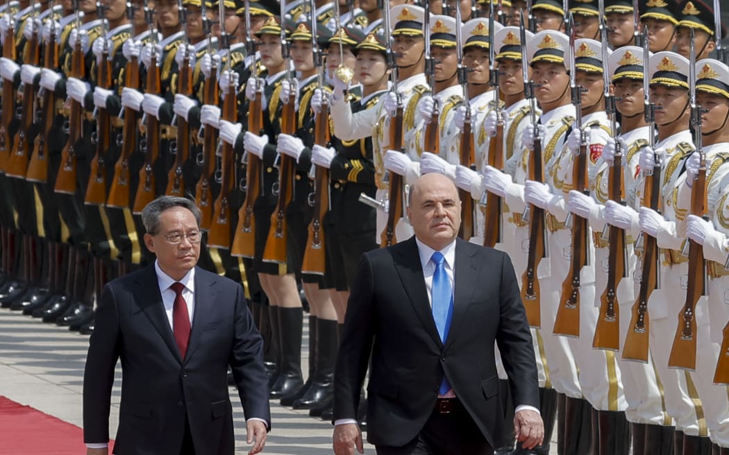 Russian Prime Minister Mikhail Mishustin (C) and Chinese Premier Li Qiang attend a welcoming ceremony in Beijing on May 24, 2023.