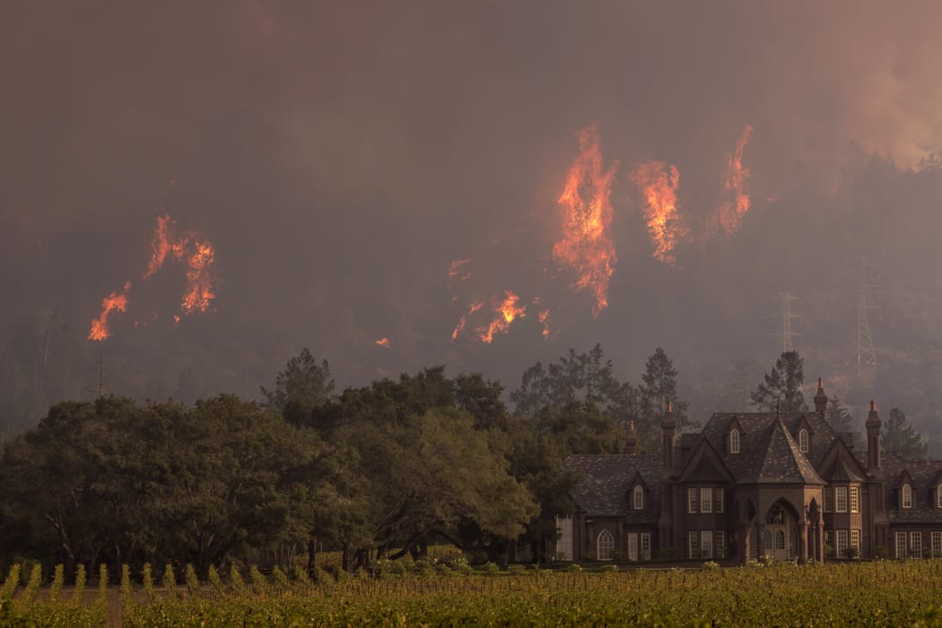 Flames rise behind Ledson Winery on 14 October 2017 in Kenwood, near Santa Rosa, California.