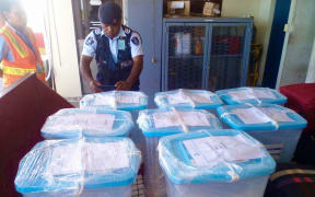 A police officer oversees the delivery of ballot boxes