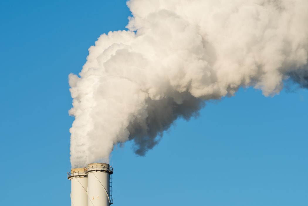 The pipe of a coal power plant with white smoke as a global warming concept.