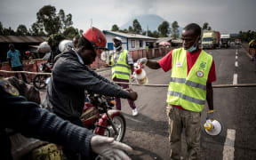 A motorcycle taxi driver gets his hands washed at an Ebola screening station on the road between Butembo and Goma, 16 July 2019.