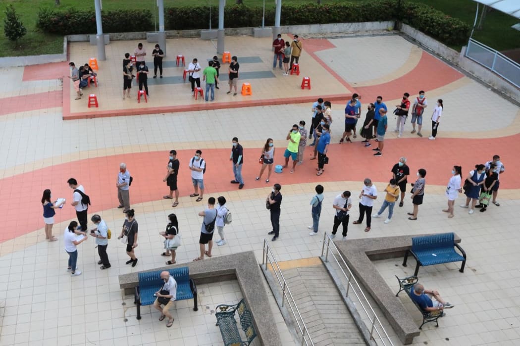 People wait in queue to register for the China-made Covid-19 Sinovac vaccine on 24 June in Singapore.