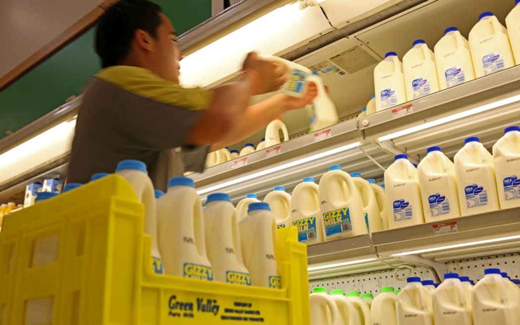 Pak n Save employee stacking milk in Gisborne.