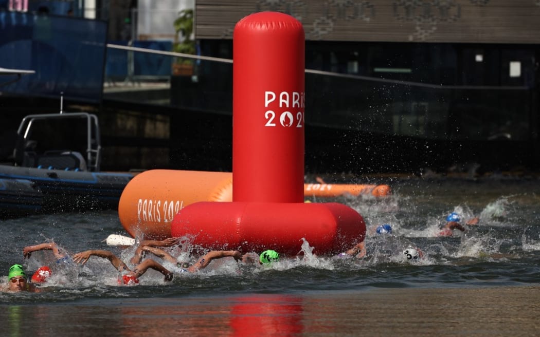 Athletes compete in the swimming stage in the Seine during the men's individual triathlon at the Paris 2024 Olympic Games in central Paris on July 31, 2024. (Photo by Anne-Christine POUJOULAT / AFP)