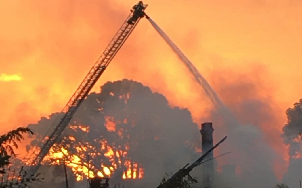 Firefighters extinguishing a large blaze at Parnell's City Garden Lodge on 7 April 2024.
