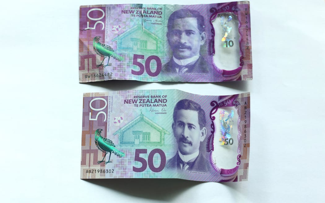 A legitimate bank note (bottom) feels like plastic and is difficult to tear, while a counterfeit bank note will hold its crumpled state if scrunched.