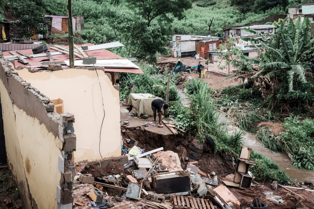 People begin to remove debris after their homes were destroyed by torrential rains and flash floods at an informal settlement of BottleBrush, south of Durban.