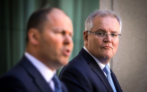 Australian Prime Minister Scott Morrison (R) reacts as he stands with the Australian Treasurer Josh Frydenberg