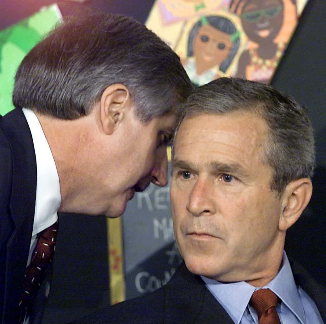White House Chief of Staff Andy Card tells US President George W. Bush about the terror attack on the World Trade Center, while Bush is reading to children at a school visit.