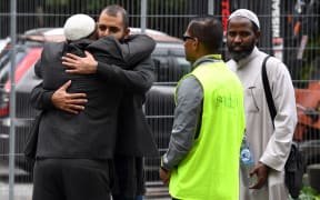 A member of the Jewish community embraces a member of the Muslim community at the Hagley Ovel makeshift information center in Christchurch.