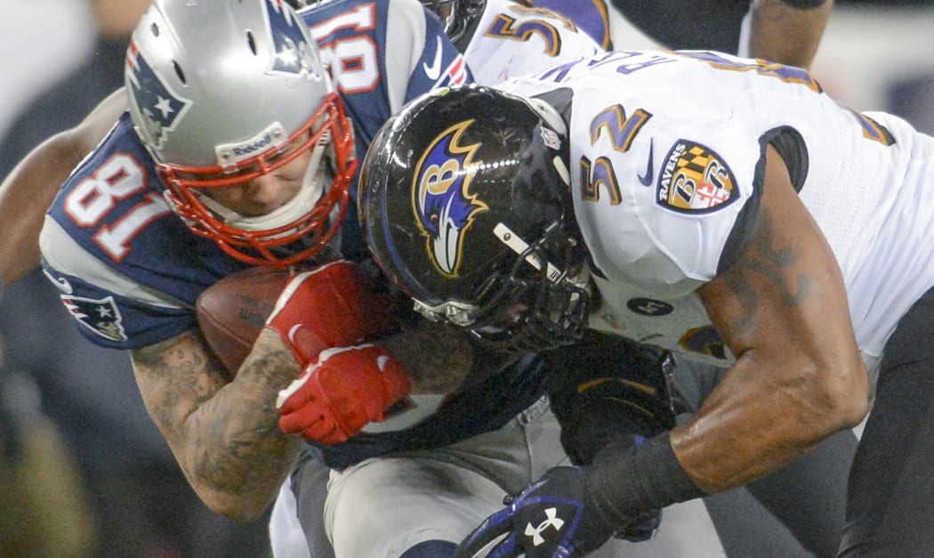 The former New England Patriots tight end Aaron Hernandez (left) is tackled by the Baltimore Ravens' Ray Lewis.