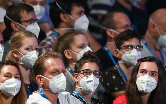 People wear face masks as German pop singer Tim Bendzko performs on stage at the Arena in  Leipzig, eastern Germany on August 22, 2020