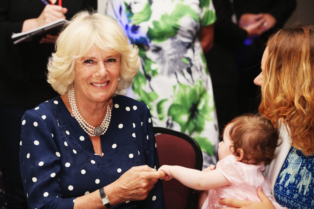 The Duchess of Cornwall interacts with a baby at Auckland charity Bellyfull