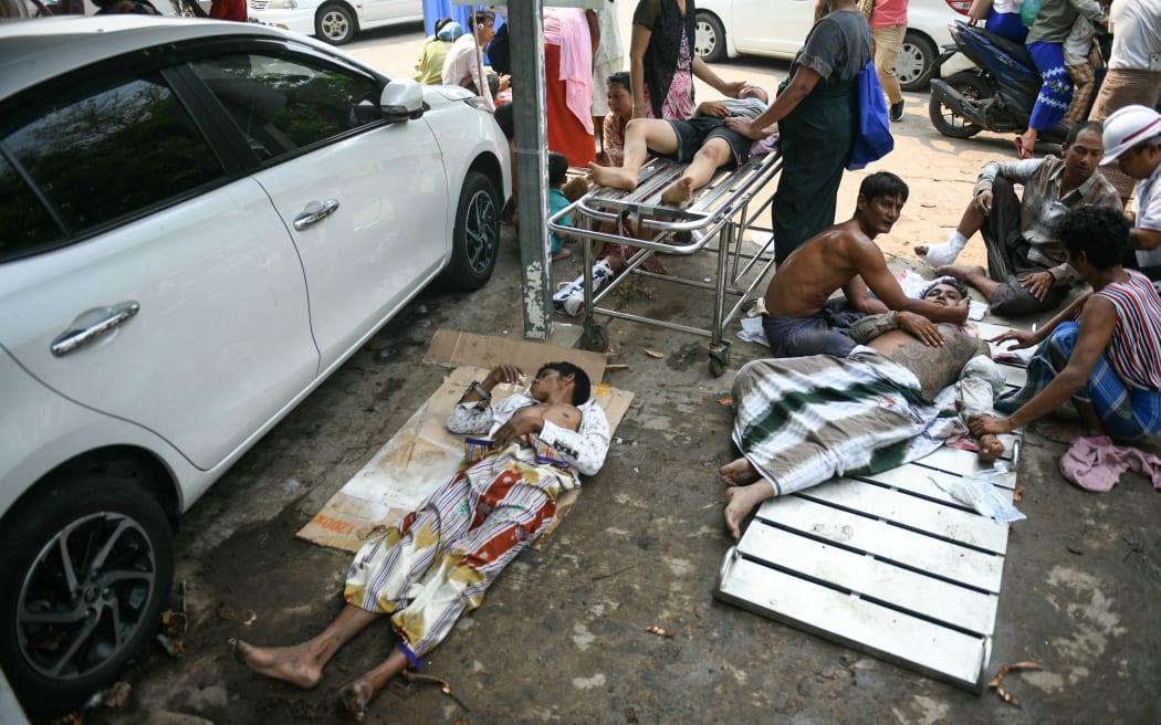 Survivors wait to receive medical attention as they lie on the ground of the compound of a hospital in Naypyidaw on March 28, 2025, after an earthquake in central Myanmar. A powerful earthquake rocked central Myanmar on March 28, buckling roads in capital Naypyidaw, damaging buildings and forcing people to flee into the streets in neighbouring Thailand. (Photo by Sai Aung MAIN / AFP)