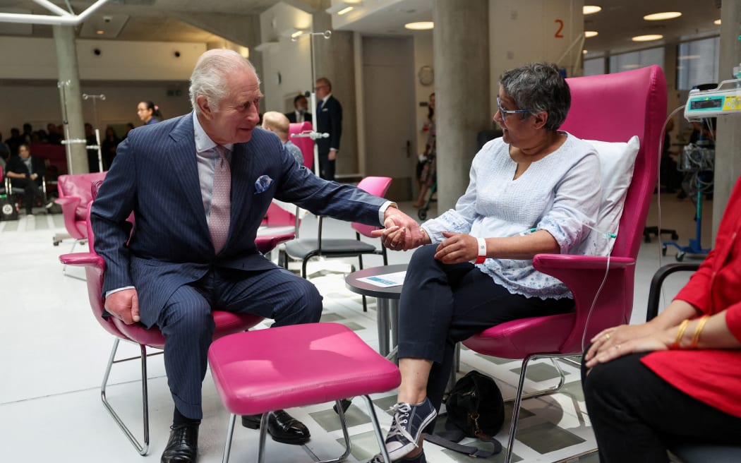 Britain's King Charles holds the hand of patient Asha Millan, during a visit to the University College Hospital Macmillan Cancer Centre in London on April 30, 2024. Charles is making his first official public appearance since being diagnosed with cancer, after doctors said they were "very encouraged" by the progress of his treatment. (Photo by Suzanne Plunkett / POOL / AFP)