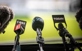 Microphones at a press conference showing RNZ, Newstalk ZB and Today FM