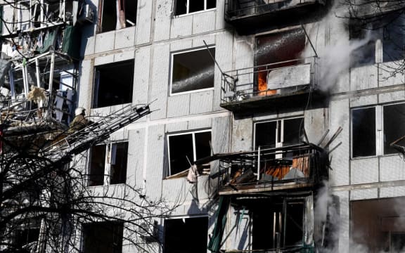 Firefighters work on a fire on a building after bombings on the eastern Ukraine town of Chuguiv on February 24, 2022, as Russian armed forces are trying to invade Ukraine from several directions, using rocket systems and helicopters